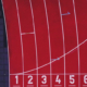 Een rode hardloopbaan, recht van boven gefotografeerd. De cijfers 1 tot en met 8 zijn zichtbaar